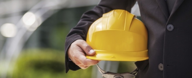 Engineer. Engineer holding protective helmet closeup shot